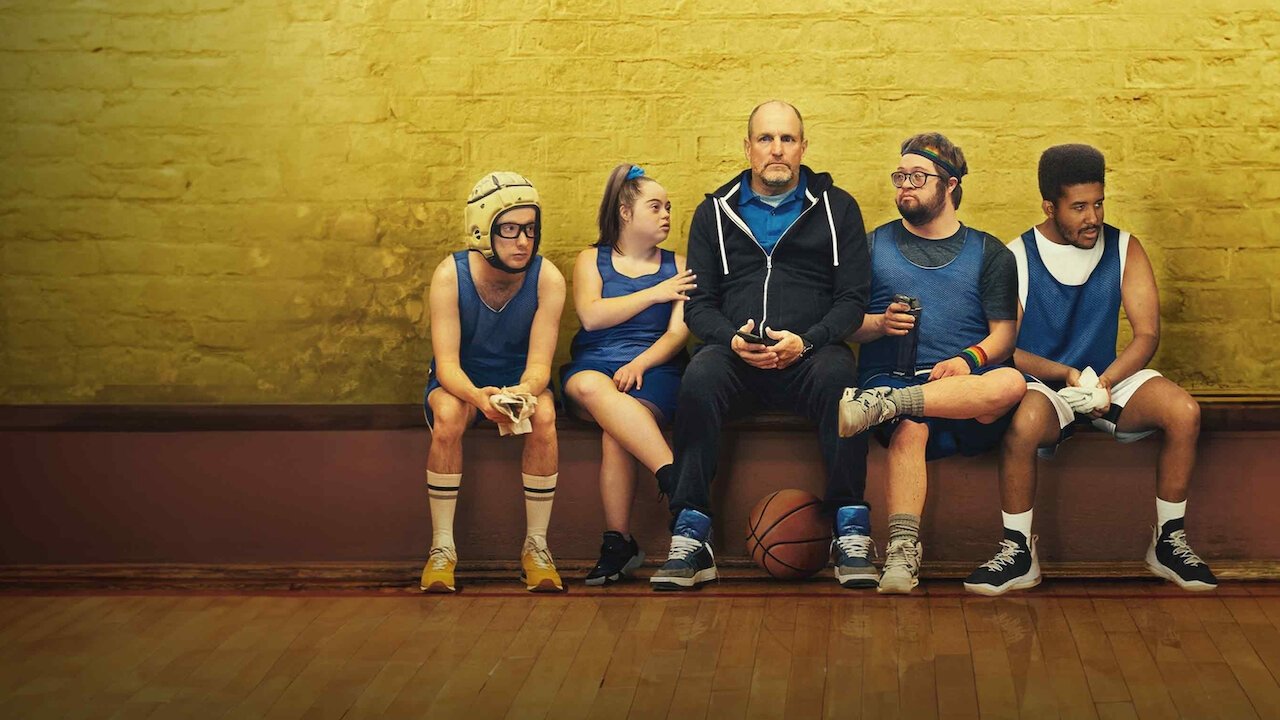 The film image shows six characters in athletic gear sitting on a bench, including actors with intellectual disabilities.