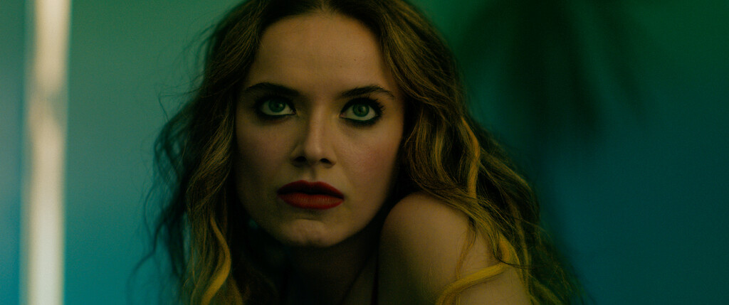 A close up shot from the film “They Kill by Night” of a woman wearing dark red lipstick and dark eyeshadow.