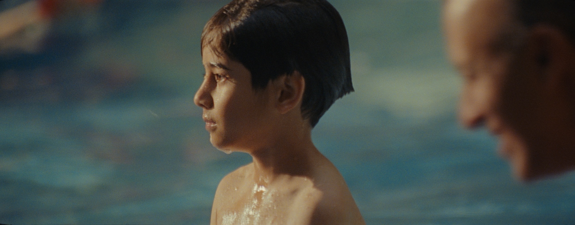 A medium shot from the film “One Day This Kid” of a kid with their hair wet.