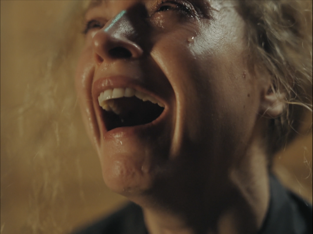 A close up shot from the film “Break Room” of a woman aggressively crying.