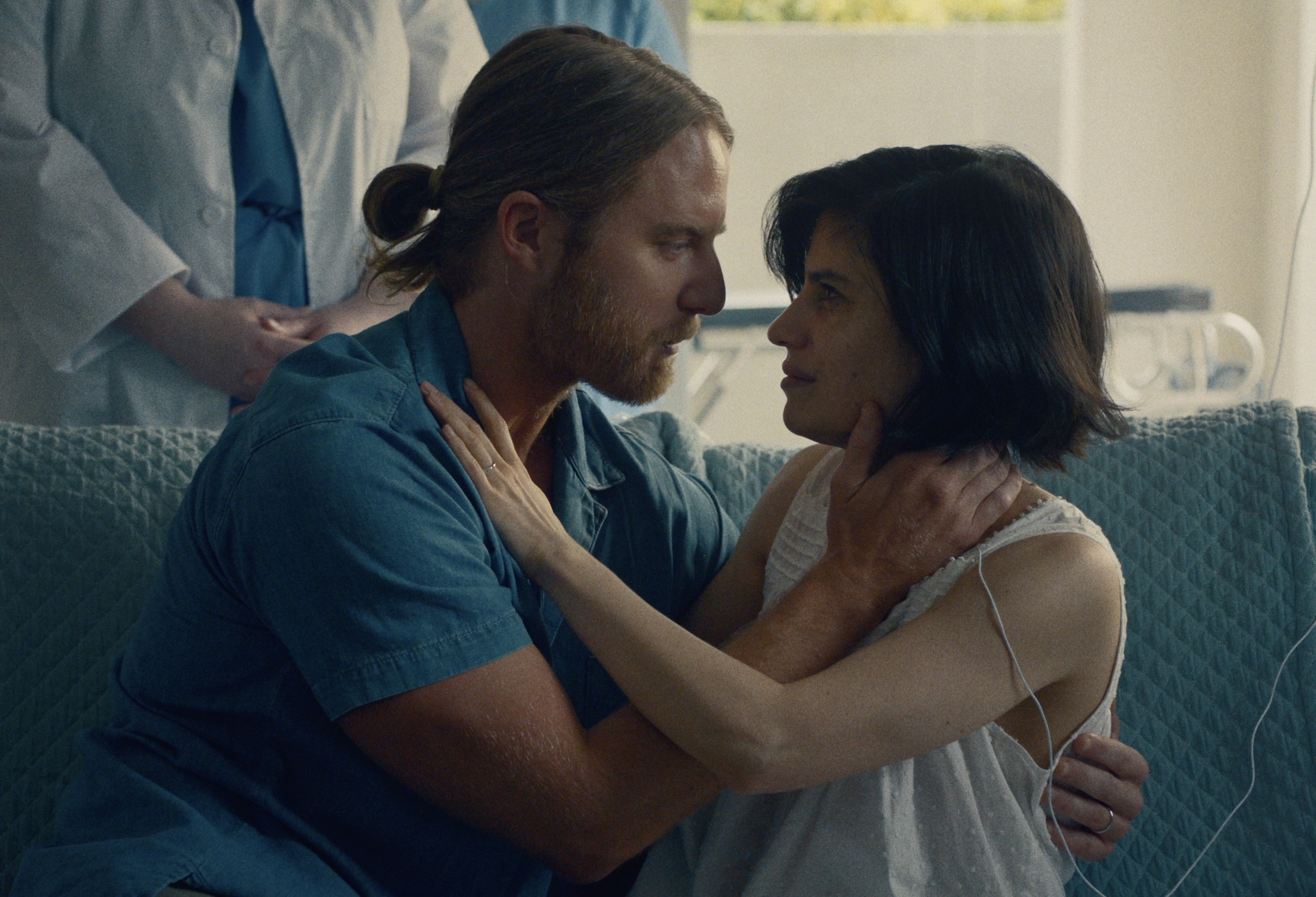 A medium shot from the film “One Last Round” of a couple embracing each other lovingly.